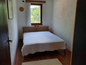 a small bedroom with a bed with a window at Villa River Pehchevo in Pehčevo
