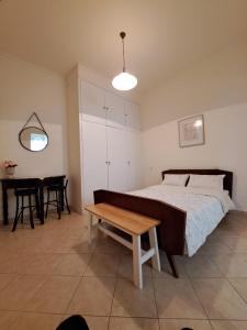 Un dormitorio con una cama y una mesa. en Persefoni's Room en Néa Kíos