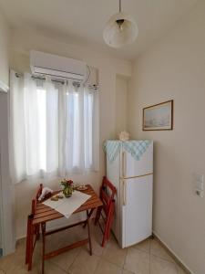 a small kitchen with a table and a refrigerator at Persefoni's Room in Nea Kios