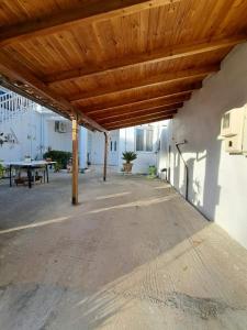 eine Terrasse mit einem Holzdach und einem Picknicktisch in der Unterkunft Persefoni's Room in Nea Kios