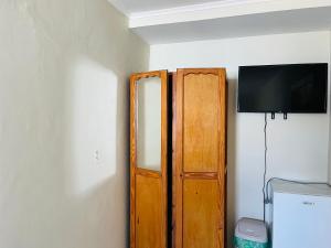 a room with a wooden door and a television at Nouvelle Orange Willemstad in Willemstad