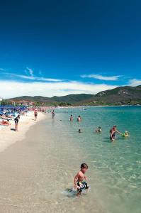 a group of people in the water at the beach at Appartamenti Casa Pineta in Marina di Campo +5 photos