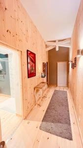 Habitación con pared de madera, mesa y alfombra. en La Grange de Grandviala en La Chaze-de-Peyre