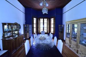 ein Esszimmer mit einem langen Tisch und blauen Wänden in der Unterkunft Villa Victoria Lodge in Maipú