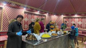 Un uomo in piedi di fronte a un buffet di cibo di Wadi Rum Khalid luxury camp a Wadi Rum