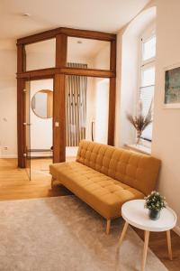 una sala de estar con un sofá y una mesa en Studio Apartment im Zentrum mit Parkplatz & neuem Badezimmer, en Magdeburgo