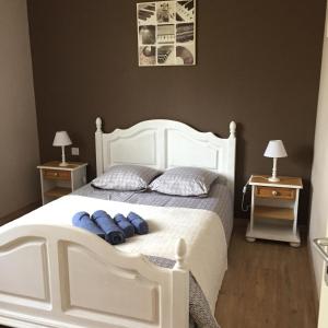 een slaapkamer met een wit bed met blauwe kussens bij Le chat perché in Saint-Julien-en-Born