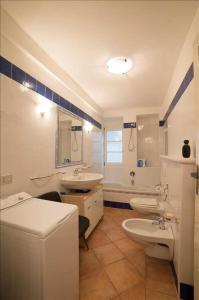 łazienka z 2 umywalkami, toaletą i wanną w obiekcie Appartamento Olga w mieście Stresa
