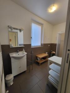 a bathroom with a sink and a toilet and a window at Red Apartment - Residenza Silvana in Verbania