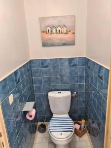 a bathroom with a toilet with a blue tiled wall at Chez Nelly in La Seyne-sur-Mer