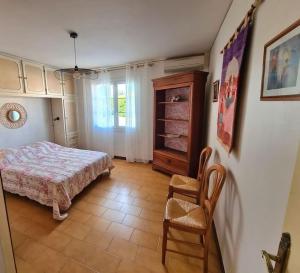 1 dormitorio con 1 cama y 1 silla en Chez Nelly en La Seyne-sur-Mer