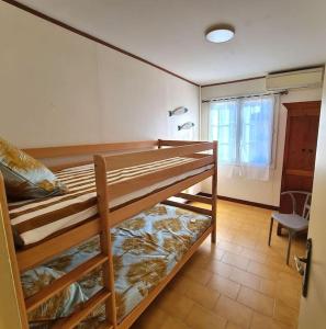 1 dormitorio con 2 literas y ventana en Chez Nelly en La Seyne-sur-Mer
