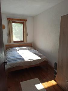 a small bedroom with a bed and a window at Villa River Pehchevo in Pehčevo