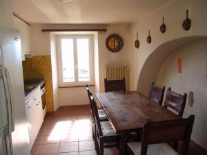 una sala da pranzo con tavolo, sedie e finestra di Casa Perini a Tenero-Contra