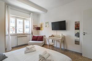 - une chambre avec un lit, un bureau et une télévision dans l'établissement Cinecittà Gem Flat with Veranda, à Rome
