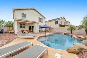a swimming pool with two lounge chairs and a house at Palm Paradise in Avondale