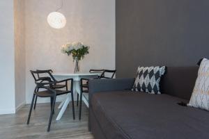ein Wohnzimmer mit einem Tisch mit Stühlen und einem Sofa in der Unterkunft Appartamento Washington 84 in Mailand