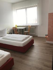 2 camas en una habitación con mesa y sillas en Landgasthof Felsenkeller en Dinkelsbühl