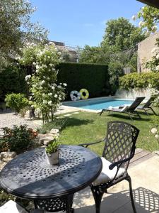 a table and a chair next to a swimming pool at B&B Temps Suspendu Provence in Pernes-les-Fontaines