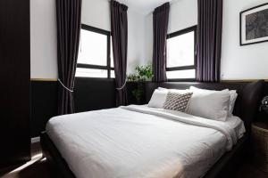 um quarto com uma grande cama branca e janelas em Heart of Tel Aviv, apartment 6 em Tel Aviv