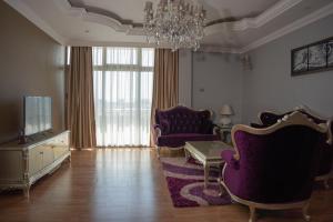 a living room with purple furniture and a chandelier at Sidra International Hotel in Addis Ababa