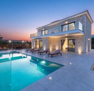 una casa con piscina frente a una casa en Kefalonia Stone Villas - Villa Petros Kefalonica en Trapezaki