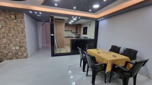 a dining room with a table and chairs and a kitchen at Stay Classy Apartments in Wadi Musa