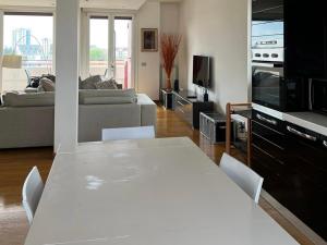 una mesa blanca y sillas en la sala de estar. en Penthouse Suite - Skyline view, en Busto Arsizio