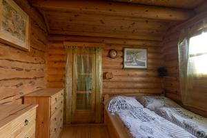 1 dormitorio con 1 cama en una cabaña de madera en Levendula Rönkház Őrség, en Zalalövő
