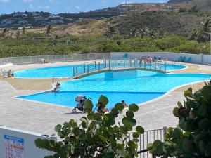a large swimming pool with people in the water at Studio Orient Bay in Orient Bay