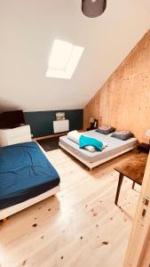 two beds in a room with wooden floors at La Grange de Grandviala in La Chaze-de-Peyre