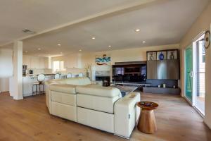 a living room with a white couch and a kitchen at The Mermaid House in San Diego