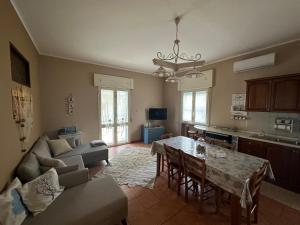 een woonkamer met een tafel en een bank en een keuken bij Sea Sunsets - Apartments - Falerna Lido - Gizzeria Lido in Gizzeria