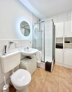 een witte badkamer met een toilet en een wastafel bij SABE APARTMENT: BALCONY + FREE PARKING + NETFLIX in Wuppertal