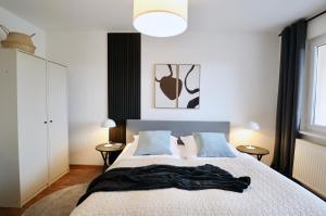 ein Schlafzimmer mit einem Bett mit einer Decke darauf in der Unterkunft SABE APARTMENT: BALCONY + FREE PARKING + NETFLIX in Wuppertal