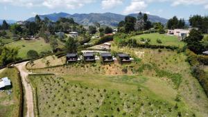 an aerial view of a farm with houses on a hill at Cumbres Luxury Glamping in Guarne