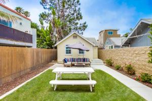 a backyard with a white table and chairs on the grass at OB Beach Daze 2 in San Diego