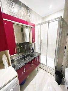 a bathroom with red cabinets and a sink and a window at House in the center of Kadikoy in Istanbul