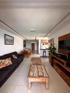 ein Wohnzimmer mit einem Sofa und einem Tisch in der Unterkunft AP ESPETACULAR VISTA MAR PRAINHA EM ARRAIAL DO CABO in Arraial do Cabo
