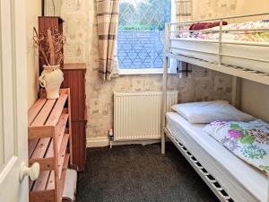 a small room with bunk beds and a window at Beach Tonic in Humberston