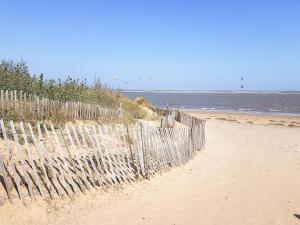 a fence on a sandy beach near the ocean at Beach Tonic in Humberston