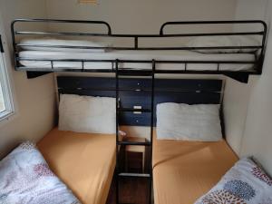 2 bedden in een kleine kamer met een stapelbed bij Mipro Mobilhome 5 in Lido di Spina +58 foto's