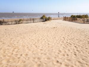 a sandy beach with a fence and the ocean at Beach Tonic in Humberston