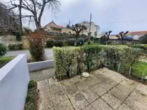 a garden with a fence and some bushes at Appartement Saint-Brevin-les-Pins, 2 pièces, 3 personnes - FR-1-364-147 in Saint-Brevin-les-Pins