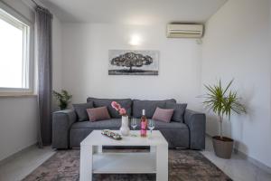 uma sala de estar com um sofá e uma mesa em Avocado Apartment em Dubrovnik