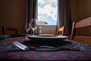 a table with a plate and two wine glasses on it at Mouse House in Gouvia