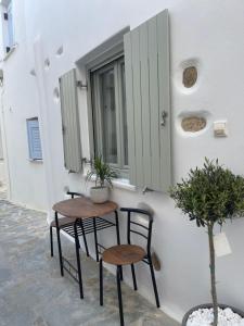 a pair of tables and chairs next to a building at Aegean White Home in Naxos Chora