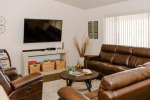 uma sala de estar com dois sofás de couro e uma televisão em Idyllic Lake Havasu Home with Pool and Jacuzzi! em Lake Havasu City