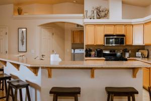 uma cozinha com um balcão e alguns bancos em Idyllic Lake Havasu Home with Pool and Jacuzzi! em Lake Havasu City