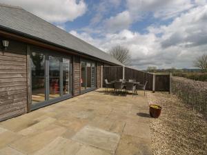 a patio with a table and chairs on it at Rectory Farm View in Queen Camel